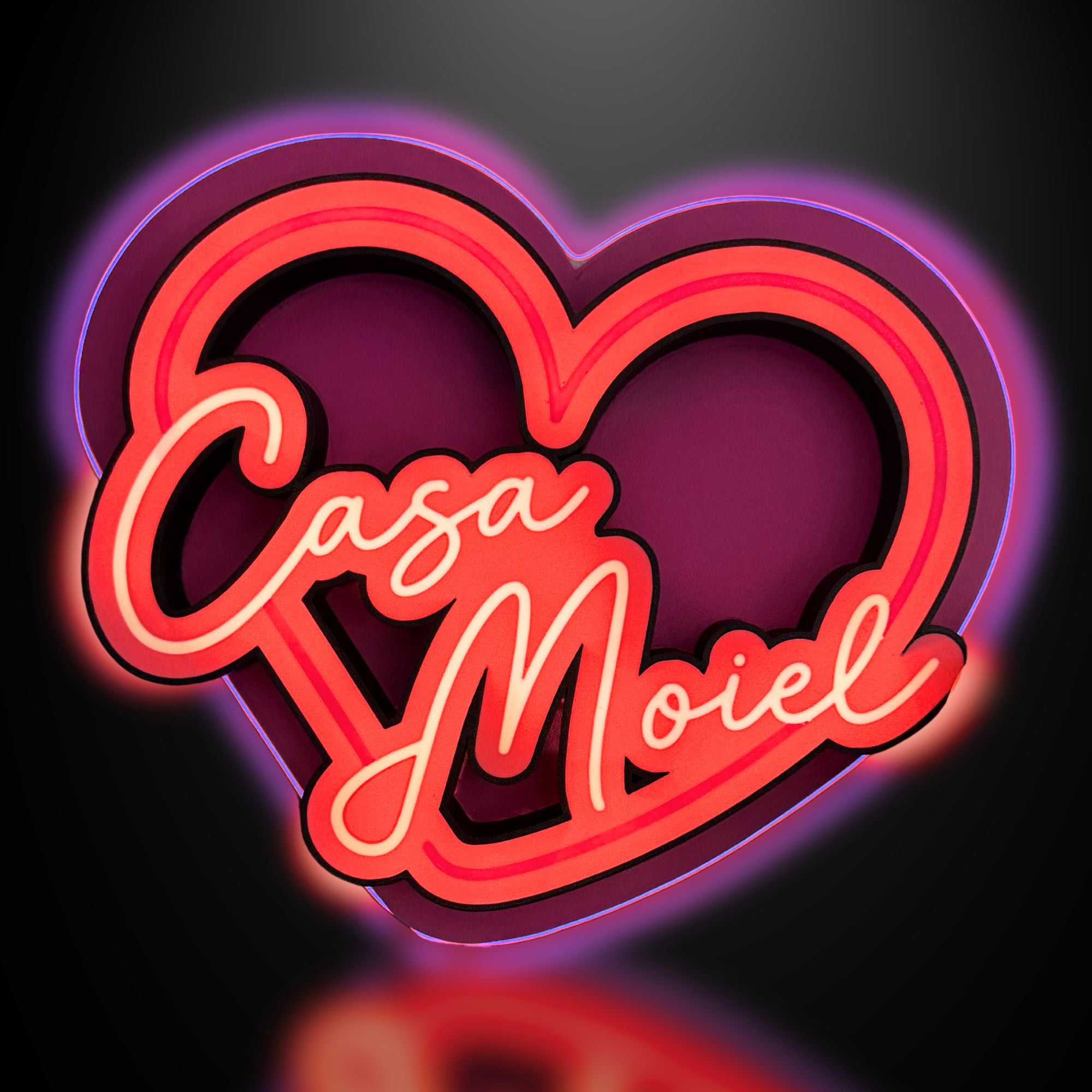 Neon sign with 'Casa Mioel' inside a heart shape on a dark background